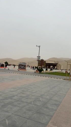 Tourists explore Dunhuang desert dunes from visitor plaza