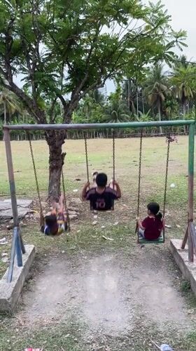 Kids on swings at a playground in Meurinya Tanjong