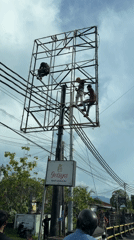 Workers perform maintenance on metal tower in Buleleng, Indonesia