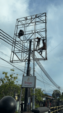 Workers perform maintenance on metal tower in Buleleng, Indonesia