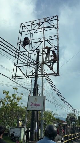 Workers perform maintenance on metal tower in Buleleng, Indonesia