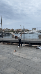 Person gestures at Barcelona yacht marina during cloudy afternoon