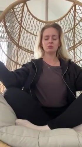 Woman practices meditation in rattan chair, self-care moment captured