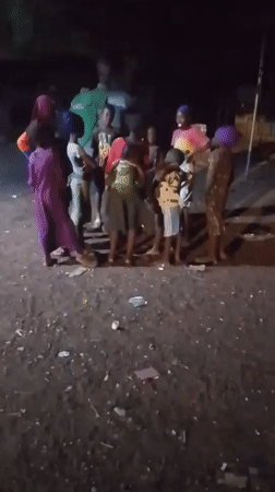 Children gather outdoors at night in Tamale, Ghana