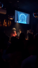 DJ performance captured at Abuja venue with animated backdrop