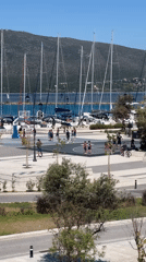 Basketball at the marina's edge, sailboats in the background