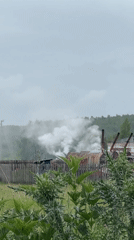 Rural industrial site with smoking kilns, damaged cars documented