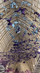 Travelers document butterfly art installation at Kuta airport terminal