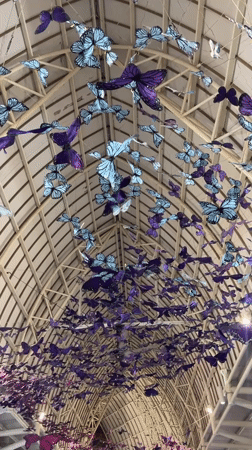 Travelers document butterfly art installation at Kuta airport terminal