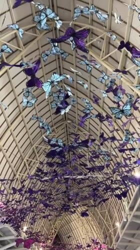 Travelers document butterfly art installation at Kuta airport terminal