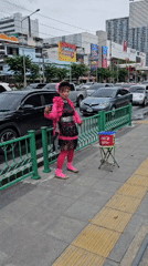 Head-to-toe pink look on a rainy Bangkok sidewalk