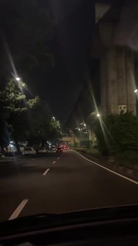 Driver travels illuminated street at night in South Jakarta
