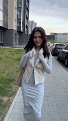 Woman in gray dress walks on brick sidewalk in Russia