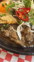 Vietnamese Bò Né breakfast captured on sizzling skillet