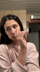 Woman brushes teeth in Sutomore bathroom morning routine