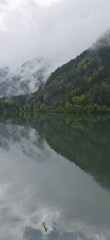 Morning fog shrouds mountain lake near Benasque, Spain