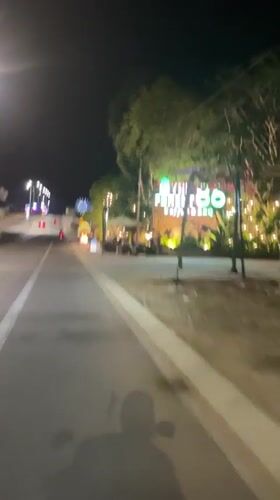 Moving vehicle captures Vietnam coffee shop on dimly lit street