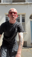 Tattooed man in pink sunglasses spotted outside London building