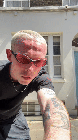 Tattooed man in pink sunglasses spotted outside London building