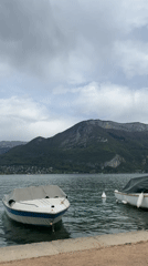 Quiet afternoon documented along Lake Annecy's boat-lined shores