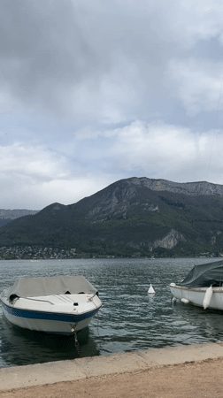 Quiet afternoon documented along Lake Annecy's boat-lined shores