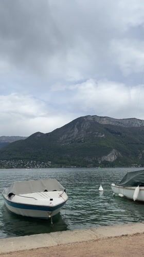 Quiet afternoon documented along Lake Annecy's boat-lined shores