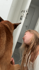 Woman plays with brown dog on floor in Ariel