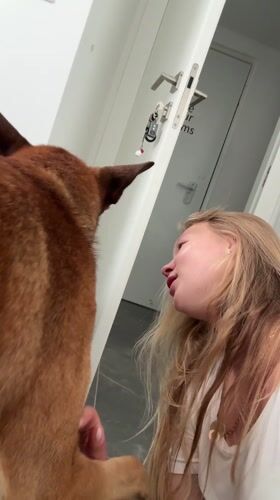 Woman plays with brown dog on floor in Ariel
