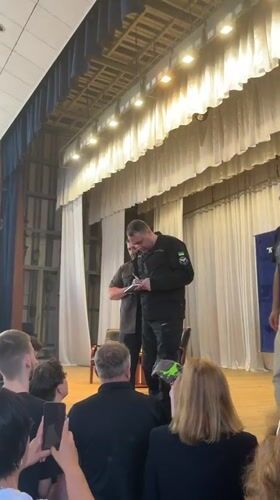 Book signing on a Kyiv stage, Ukrainian flag patches on uniform
