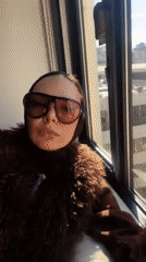 Person films self by window overlooking Osaka cityscape