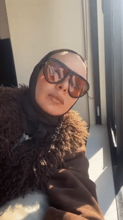 Person films self by window overlooking Osaka cityscape