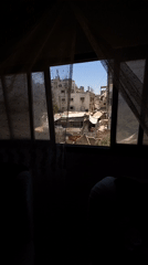 Damaged Gaza buildings seen through interior windows