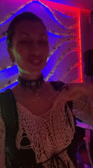 Woman dances in colorfully lit room in North Kuta