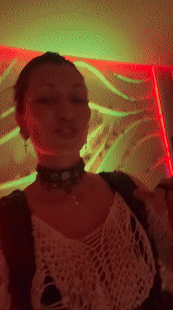 Woman dances in colorfully lit room in North Kuta