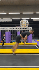 Man performs acrobatic stunts at indoor trampoline facility