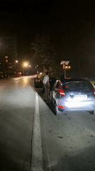 Three people gather near parked cars in Gabrovo