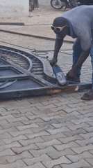 Man operates angle grinder outdoors in Gwagwalada, Nigeria