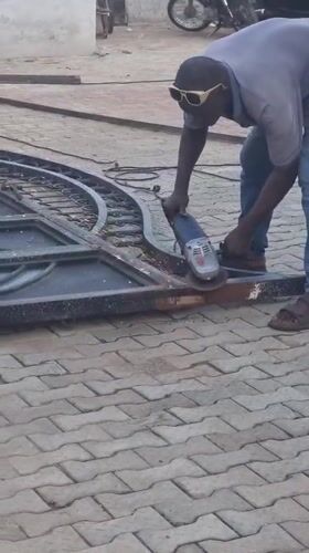 Man operates angle grinder outdoors in Gwagwalada, Nigeria