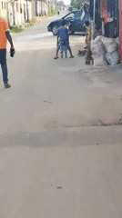 Person in orange shirt walks street in Ohokobe Ndume