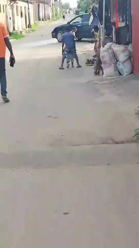 Person in orange shirt walks street in Ohokobe Ndume