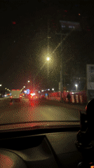 Vehicle approaches police traffic stop in Laval at night