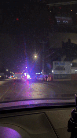 Vehicle approaches police traffic stop in Laval at night