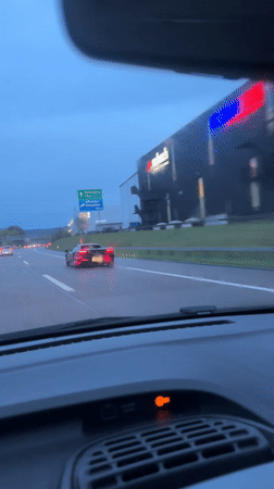 Black sports car spotted on rainy Swiss highway
