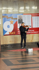 Violinist performs on box indoors in Moscow