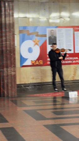 Violinist performs on box indoors in Moscow