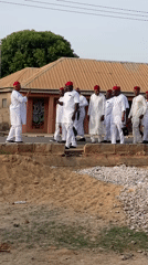 Men in traditional white attire gather in rural Nigeria