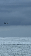Aircraft descends over Indonesian waters as fishermen work nearby