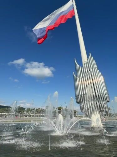 Afternoon at Sirius plaza: fountain, flag, and people out