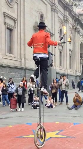Fire juggling unicyclist performs in Santiago square