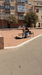 Scooter rider performs jump stunt in Spanish urban square
